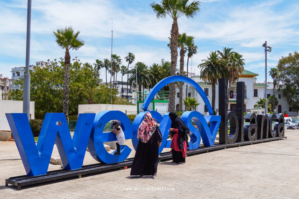 Gesluierde vrouwen voor een toeristisch 'Casablanca' bord