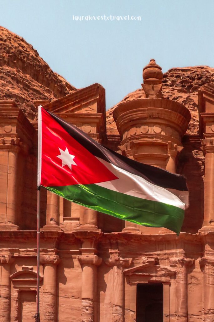 Waving flag of Jordan in front of the Monastery in Petra