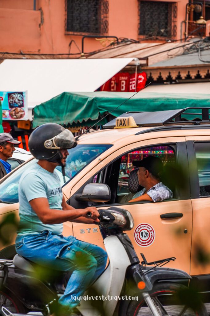 Taxis and motor scooters waiting for passengers in Marrakesh