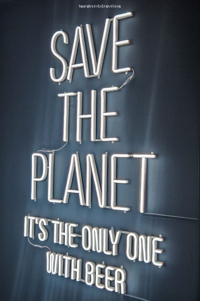 Signing on a wall with the text: Save the planet, it's the only one with beer